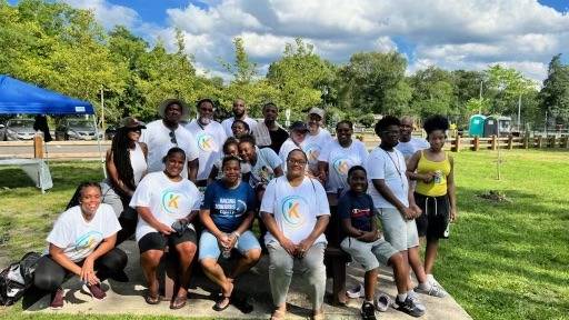 interactive community collaboration, excited expression, creating art, photorealistic, park setting with trees and flowers, highly detailed, birds flying, wide aperture, pastel tones, golden hour lighting, shot with a 50mm lens.