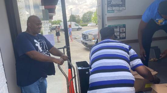charismatic public speaker, passionate expression, delivering a speech, photorealistic, auditorium filled with engaged audience, highly detailed, animated gestures and microphones, Sony A7R IV, warm earthy tones, spot lighting, shot with a 70-200mm telephoto lens.